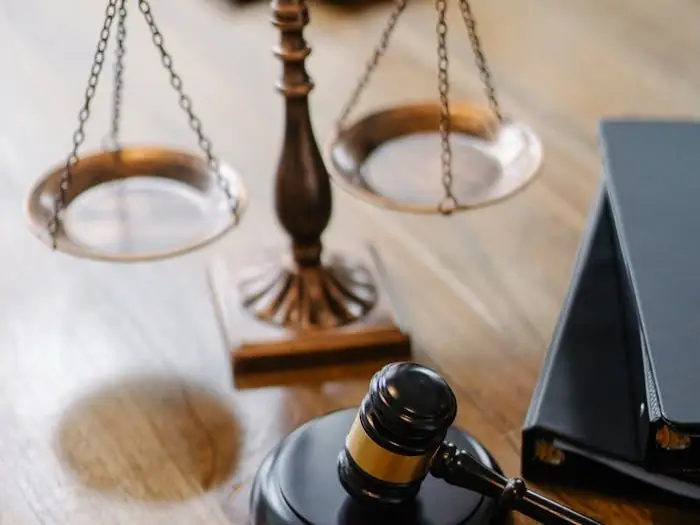 A striking image featuring a brass justice scale and gavel on a wooden desk, symbolizing law and justice.